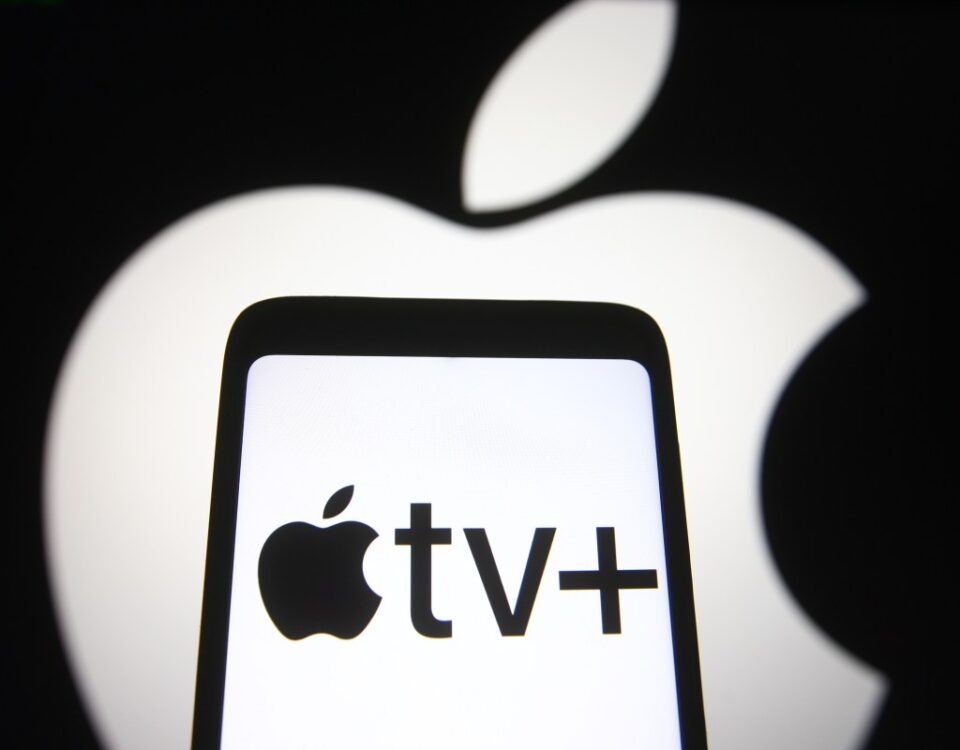 In this photo illustration an Apple TV+ logo is seen on a smartphone screen with an Apple logo in the background.