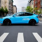 Light blue Revel rideshare mid-street