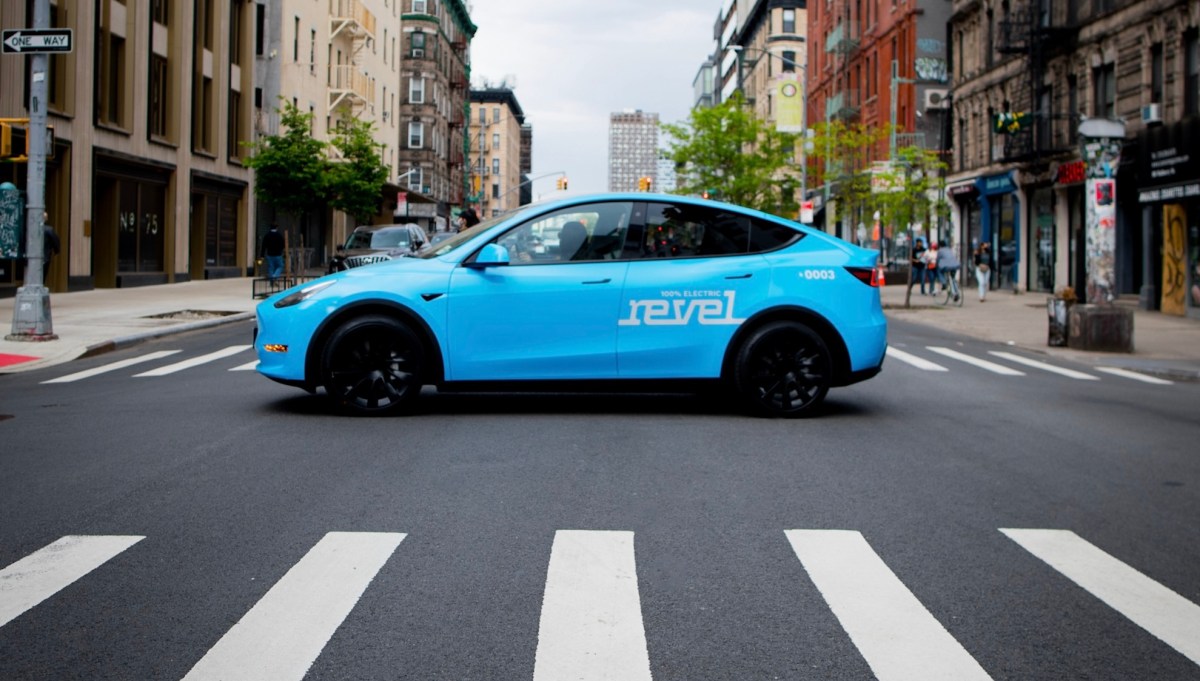 Light blue Revel rideshare mid-street