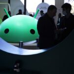 Attendees visit the Google booth where a model of the Android logo is on display at CES 2023 at the Las Vegas Convention Center.