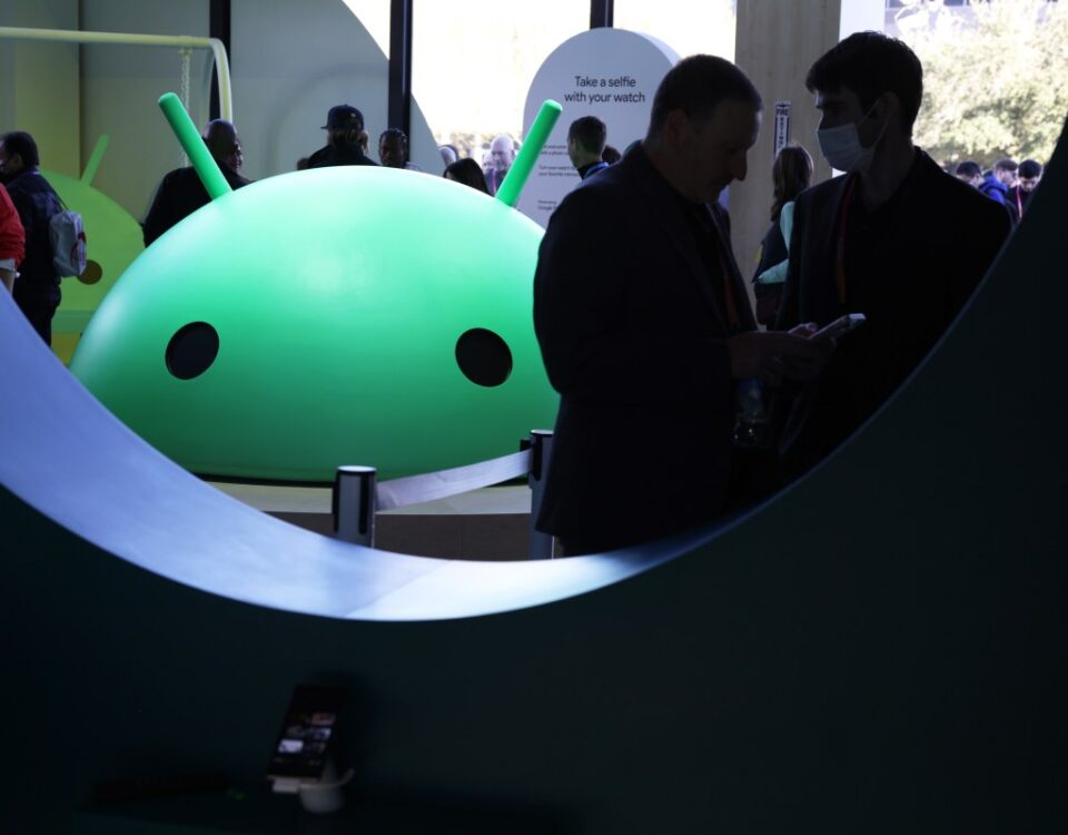 Attendees visit the Google booth where a model of the Android logo is on display at CES 2023 at the Las Vegas Convention Center.