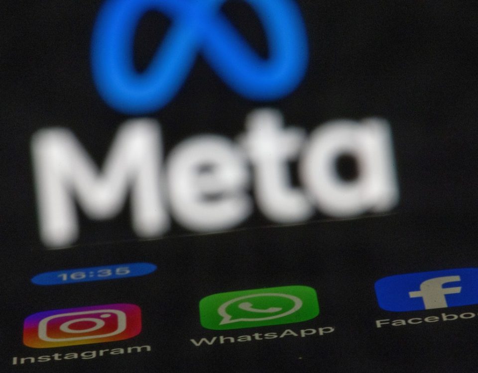 The apps Instagram, Facebook and WhatsApp can be seen on the display of a smartphone in front of the logo of the Meta internet company.