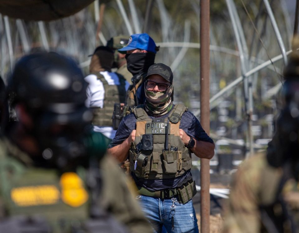 A US Immigration and Customs Enforcement agent watches as Customs and Border Protection officers hold the line against protestors who responded to a Federal Immigration raid at Glass House Farms in Camarillo, California, July 10, 2025.