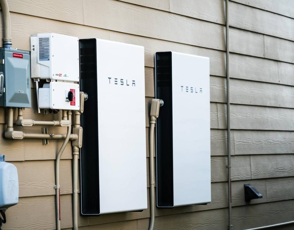 Two Tesla Powerwalls sit on the outside of a house.