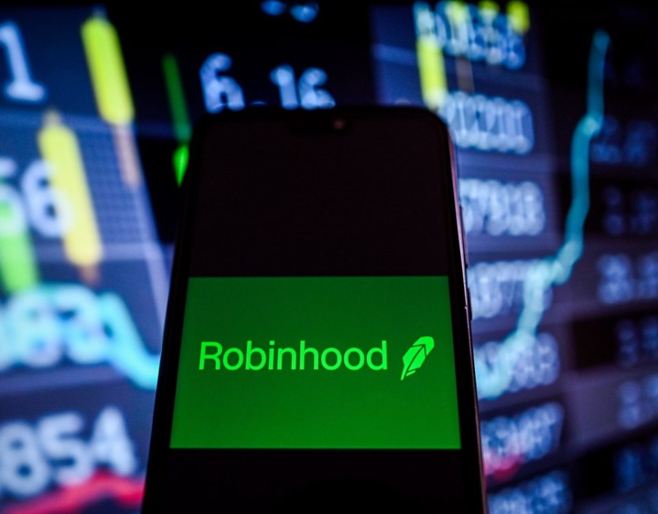 This photo illustration shows a Robinhood logo is displayed on a smartphone with stock market percentages on the background.