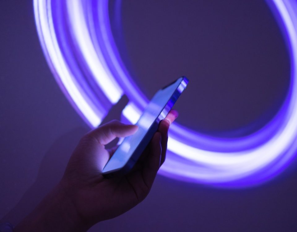 someone holding a phone on a neon purple background