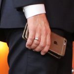 France's President Emmanuel Macron holds his mobile phones while talking with Slovakia's Prime minister during the European Social Summit in Gothenburg, Sweden