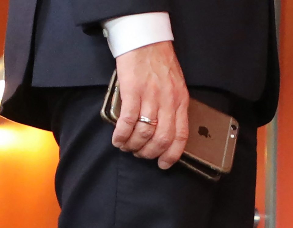 France's President Emmanuel Macron holds his mobile phones while talking with Slovakia's Prime minister during the European Social Summit in Gothenburg, Sweden