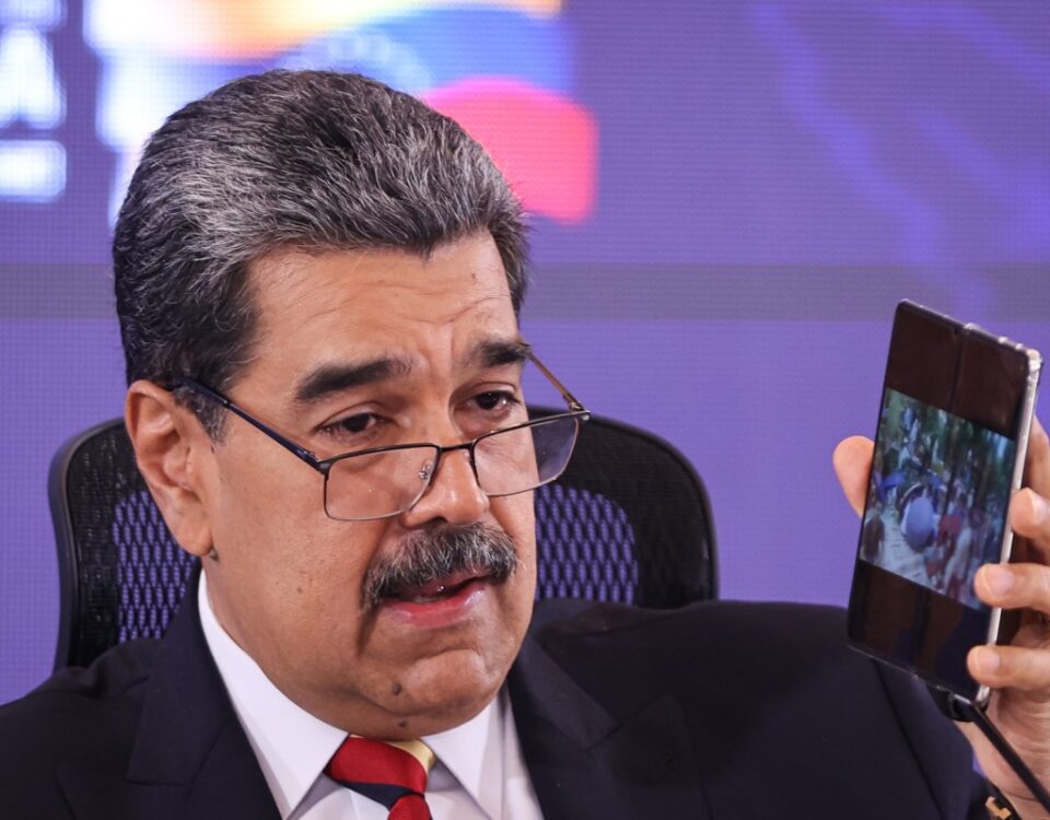 President of Venezuela Nicolás Maduro shows his cell phone during a press conference