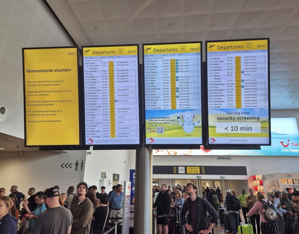 This photograph shows passengers waiting next to a flight information board of the Brussels Airport in Brussels on September 20, 2025, after the airport's system was hit by a "cyberattack" overnight on September 19.