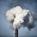 Thick smoke billowing out of the chimney of a Chinese factory.