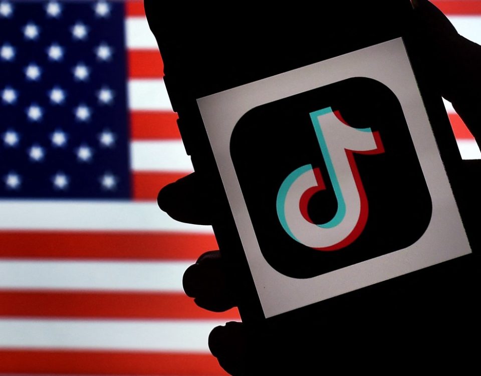 In this photo illustration, the social media application logo, TikTok is displayed on the screen of an iPhone on an American flag background on August 3, 2020 in Arlington, Virginia. - The US Senate voted on August 6, 2020, to bar TikTok from being downloaded onto US government employees' telephones, intensifying US scrutiny of the popular Chinese-owned video app. The bill passed by the Republican controlled Senate now goes to the House of Representatives, led by Democrats. (Photo by Olivier DOULIERY / AFP) (Photo by OLIVIER DOULIERY/AFP via Getty Images)
