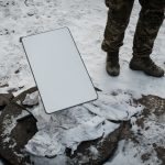 A Ukrainian serviceman stands next to the antenna of the Starlink satellite-based broadband system in Bakhmu.