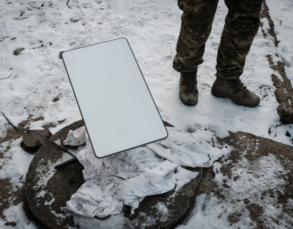 A Ukrainian serviceman stands next to the antenna of the Starlink satellite-based broadband system in Bakhmu.