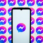 In this photo illustration, Messenger logos are displayed on a smartphone screen and on a computer screen.