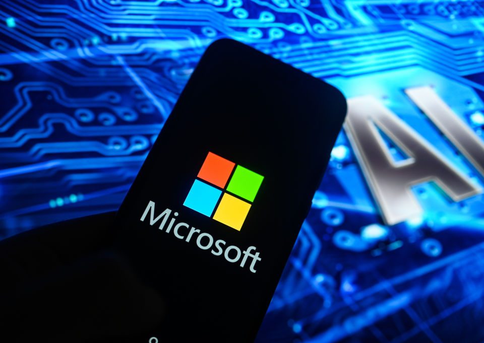Image of a smart phone with the Microsoft logo on it with "AI" in the background, Nscale