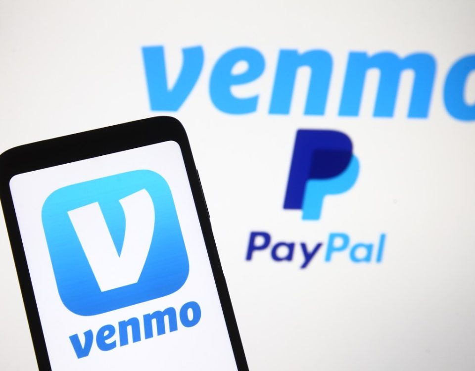 Venmo logo, a mobile payment service of PayPal is seen displayed on a smartphone and a PC screen.
