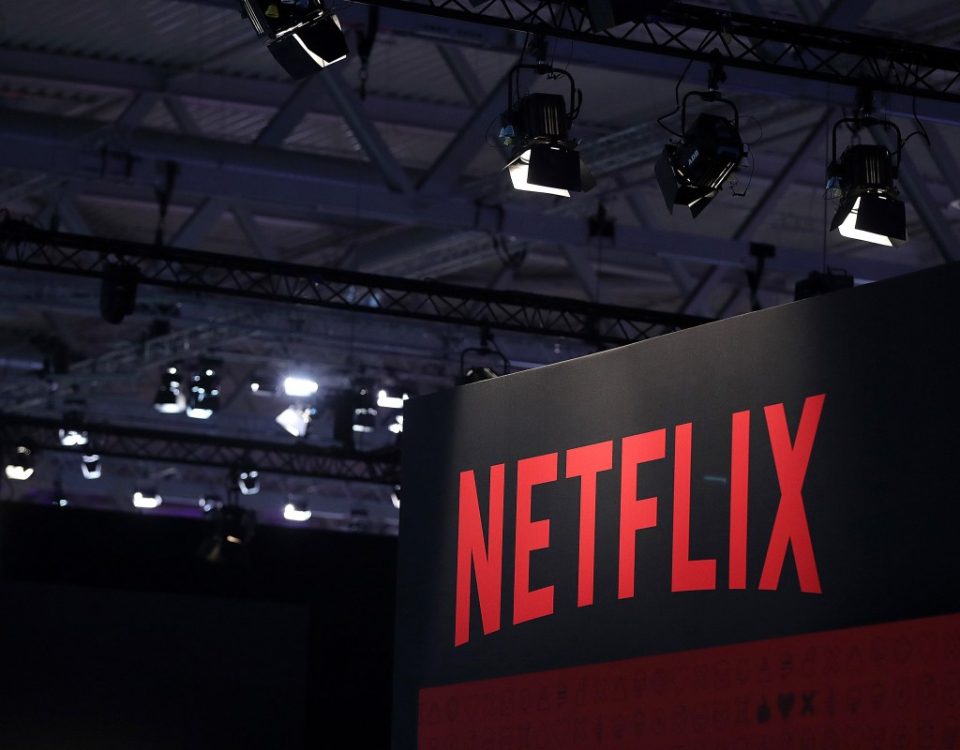 A Netflix Inc. logo sits on the online television streaming company's exhibition area at the Gamescom gaming industry event in Cologne, Germany