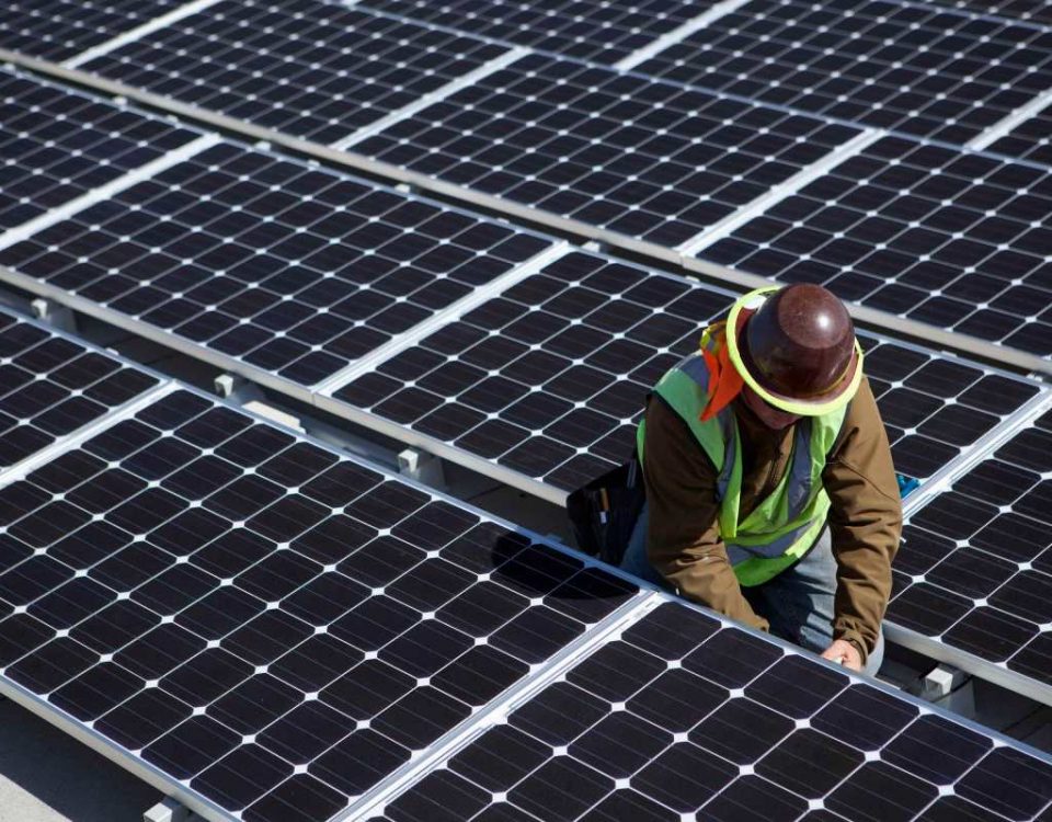 A man inspects solar panels.