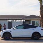 white Tesla Model Y parked in front of a house