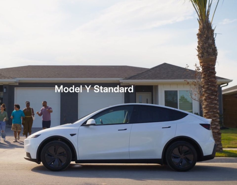 white Tesla Model Y parked in front of a house