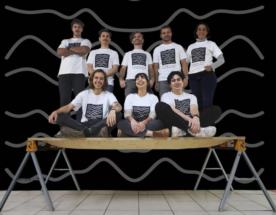Eight people stand and sit on a thin panel of wood to demonstrate its strength.