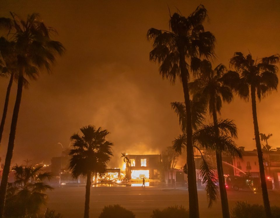 A firefighter watches the flames from the Palisades Fire burning homes on the Pacific Coast Highway amid a powerful windstorm on January 8, 2025 in Los Angeles, California.