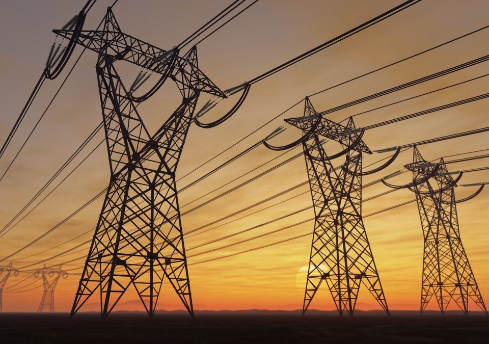 The silhouette of the high voltage power lines during sunset.