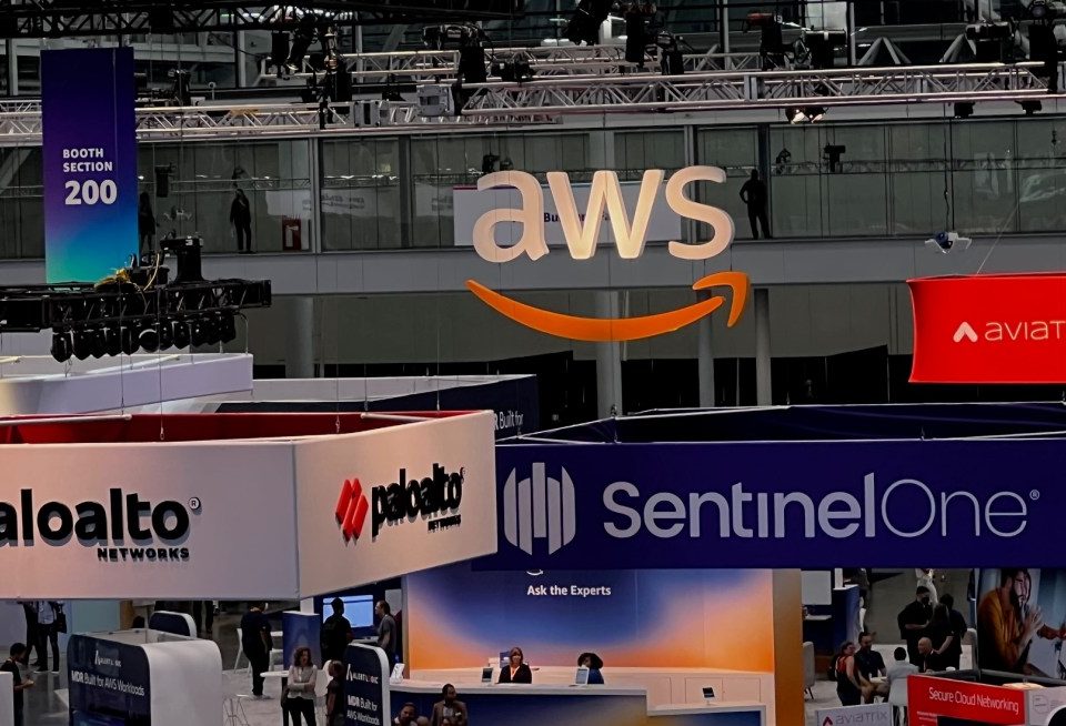 Conference floor with booths from companies like AWS, Palo Alto Networks, Rapid 7 and others taken from above.
