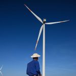 A man in front of a wind turbine in Vietnam