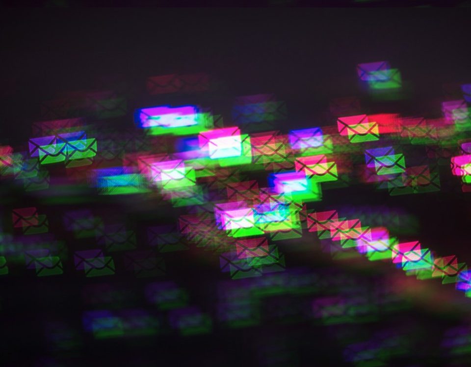 a pattern of multicolored photo-moshed envelopes flowing across on a dark background