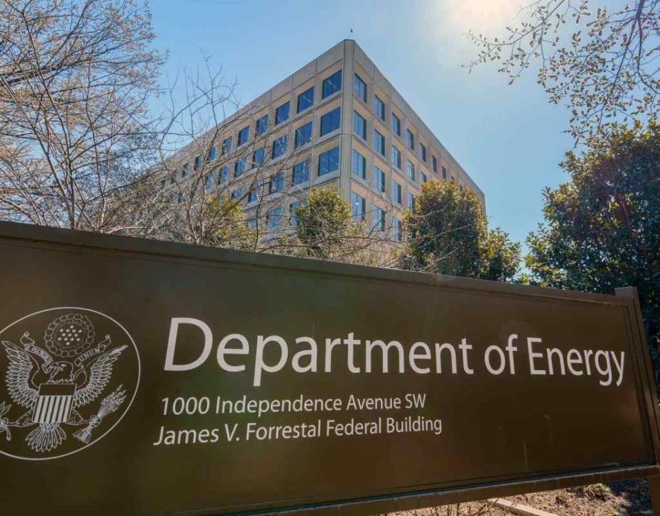 The U.S. Department of Energy building is seen behind a sign marking the location of the agency's headquarters.