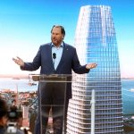 Marc Benioff standing at a podium in front of a backdrop of Salesforce Tower.