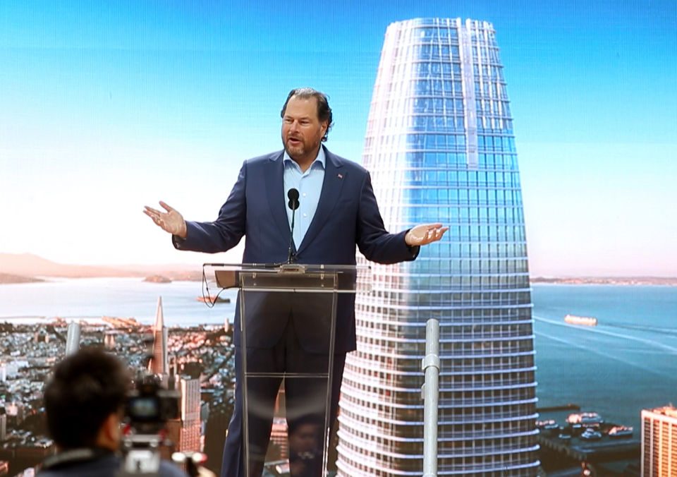 Marc Benioff standing at a podium in front of a backdrop of Salesforce Tower.